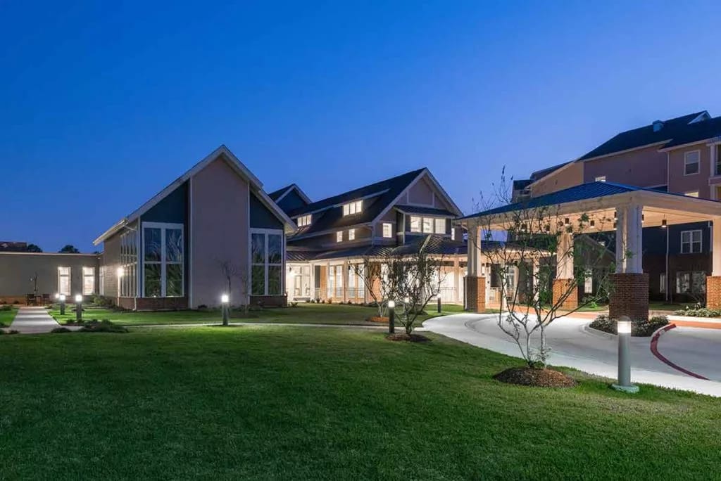 Exterior view of The Crossings Retirement Community at dusk