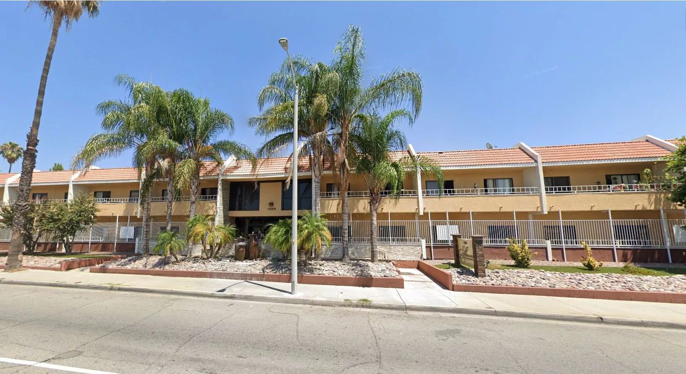 Exterior view of Abria Del Cielo facility with palm trees