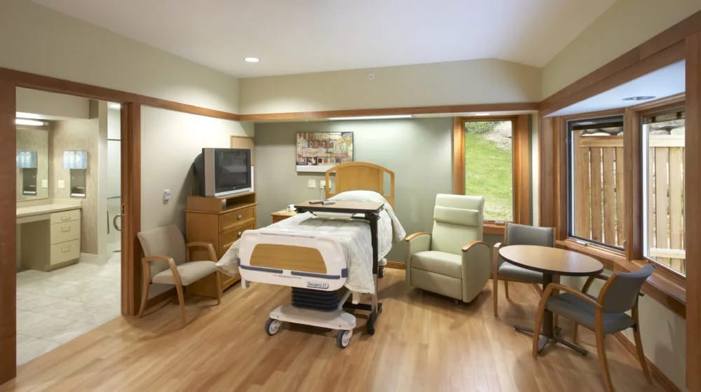Bright and spacious private resident room with a bed and seating