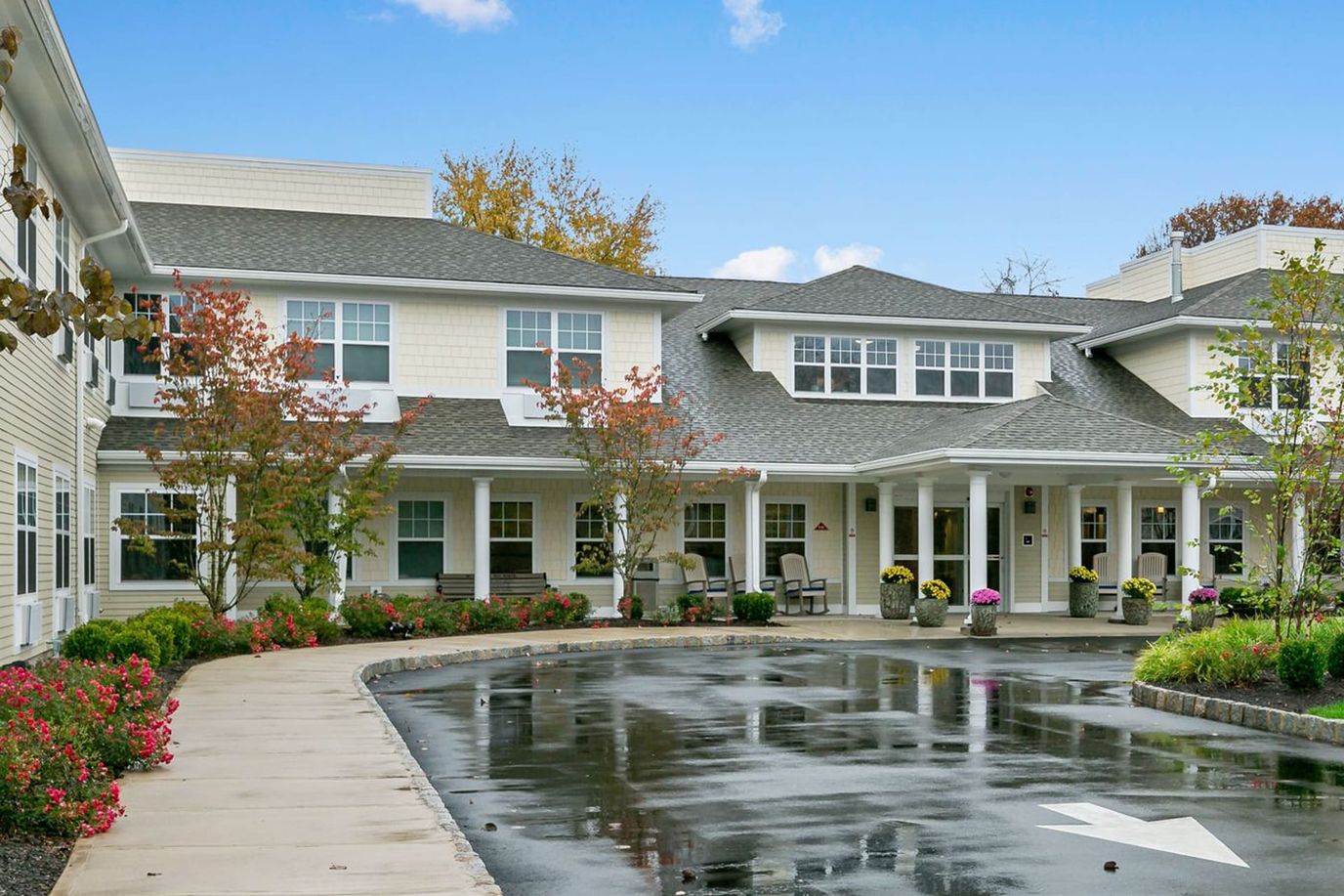 Exterior view of All American Assisted Living at Coram with gardens