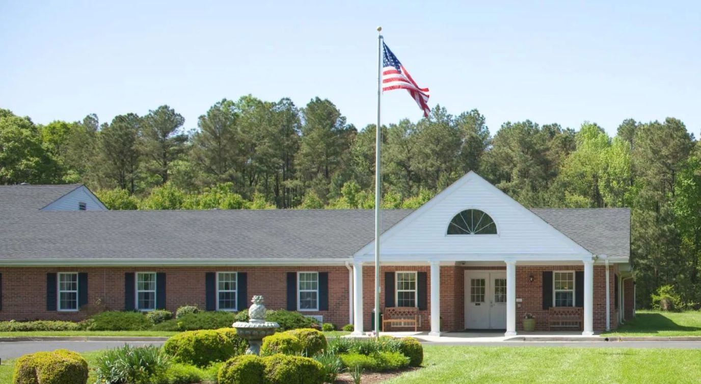 Exterior view of a senior living facility with American flag
