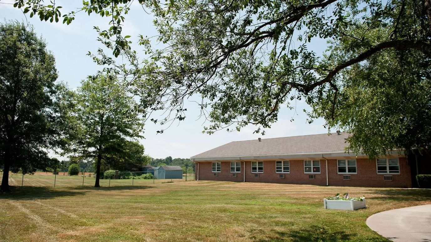 Exterior view of a senior living facility surrounded by green space