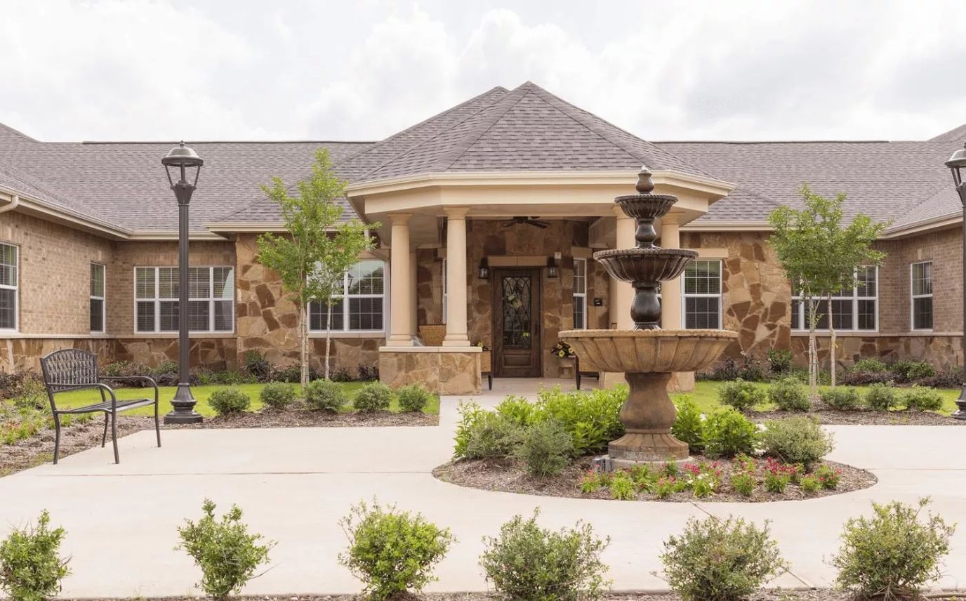 Exterior view of a senior living facility with a fountain