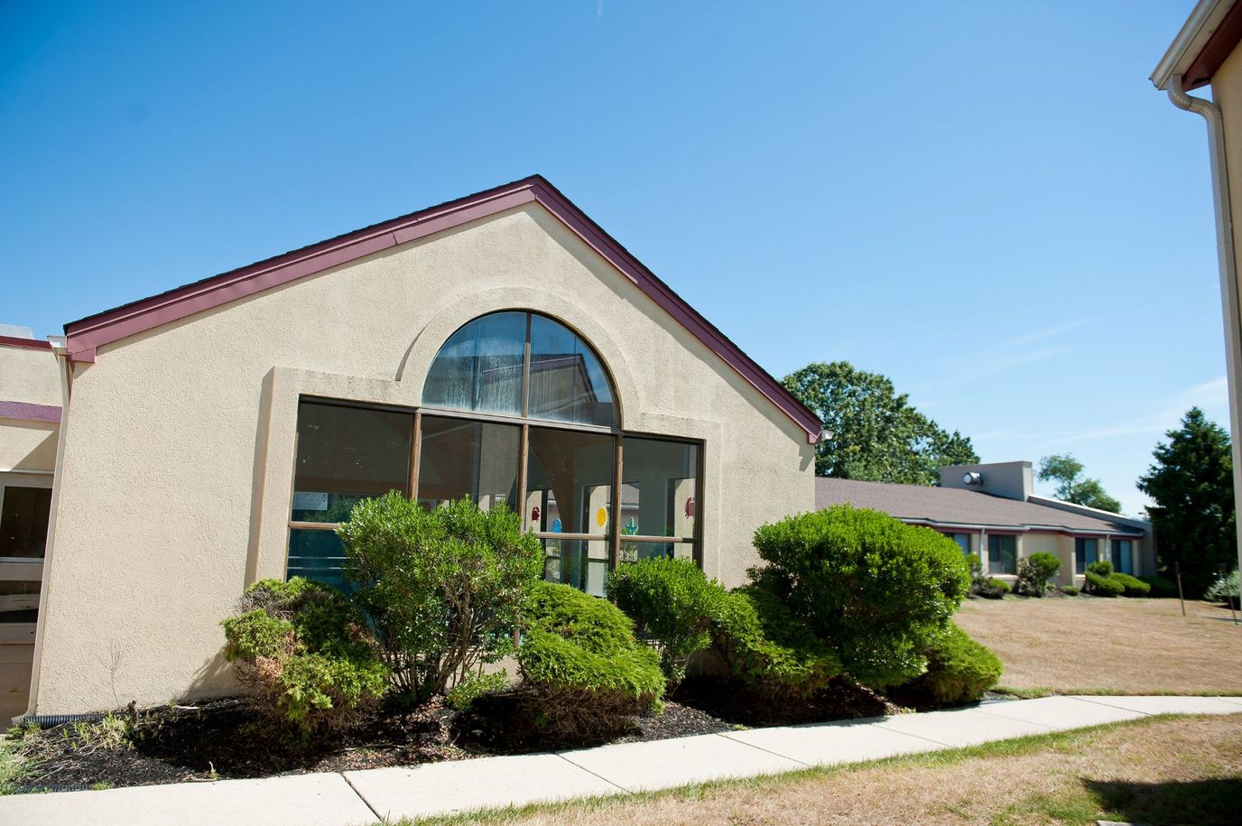 Exterior view of senior living facility with shrubs