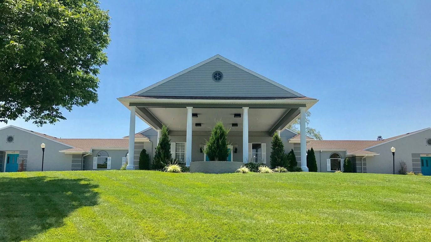 Exterior view of a senior living facility with a large lawn