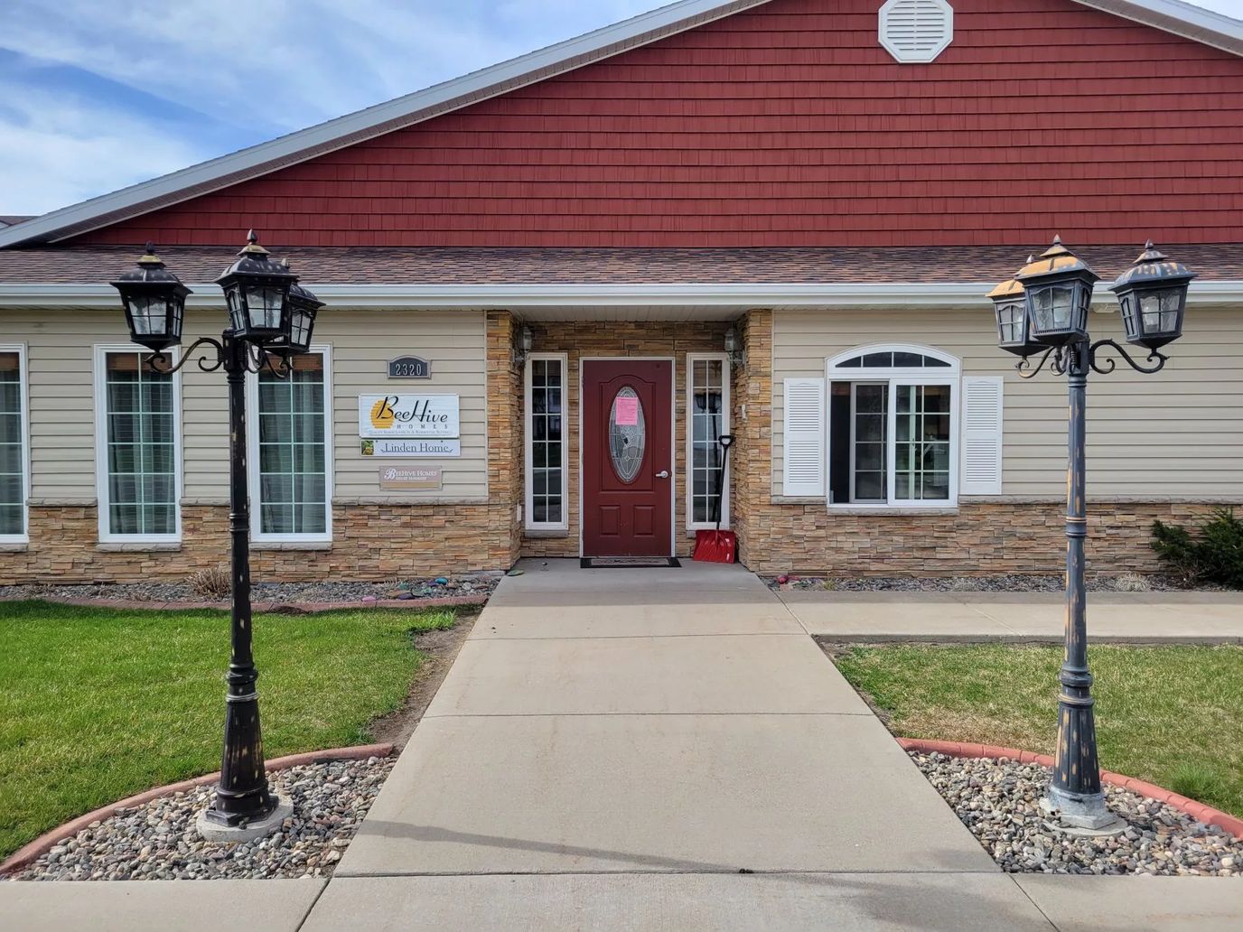 Entrance of BeeHive Homes with landscaping and outdoor lamps