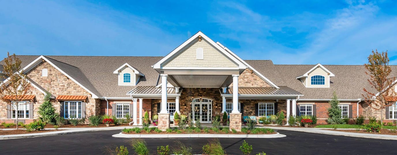 Exterior view of a senior living facility with landscaped entrance
