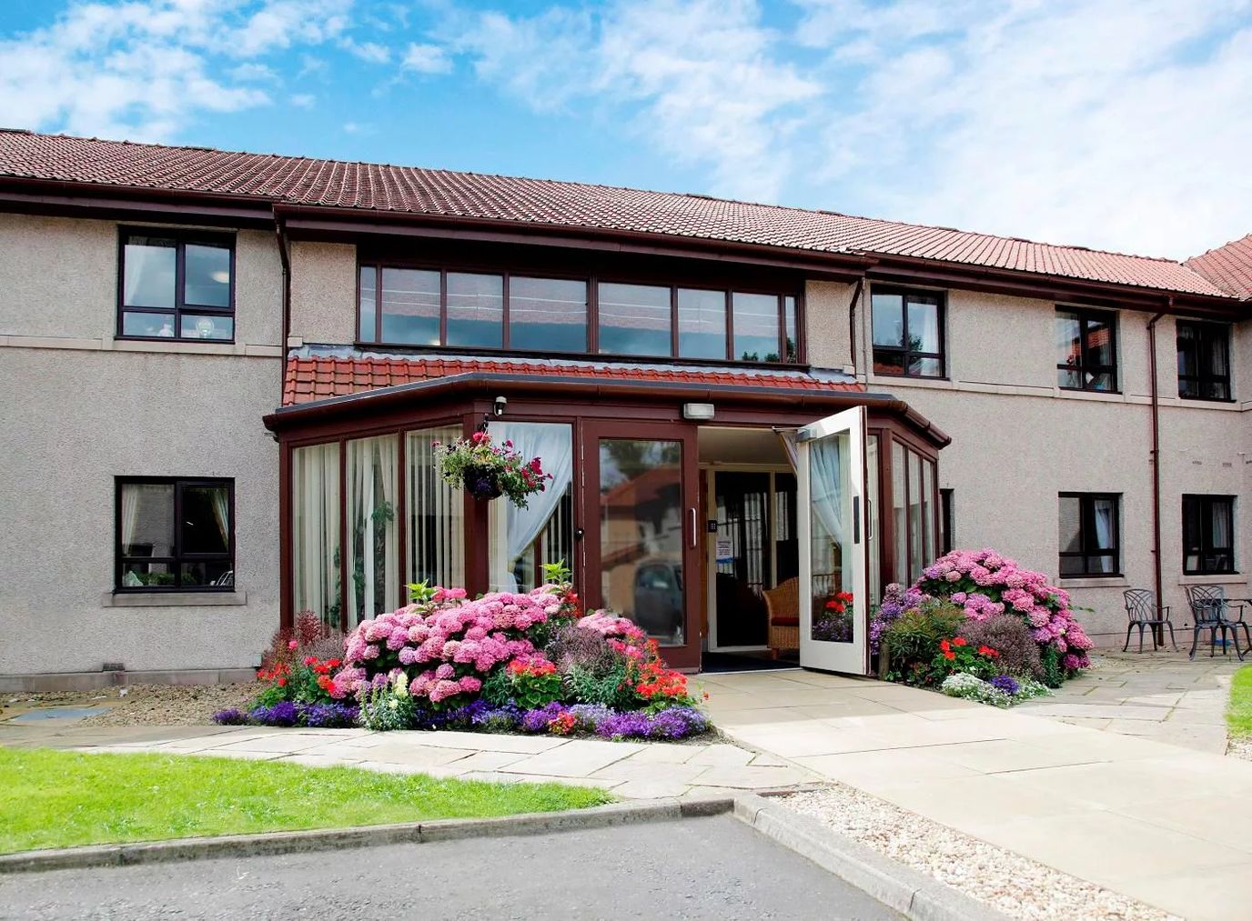 Front entrance of a senior living facility with flowers