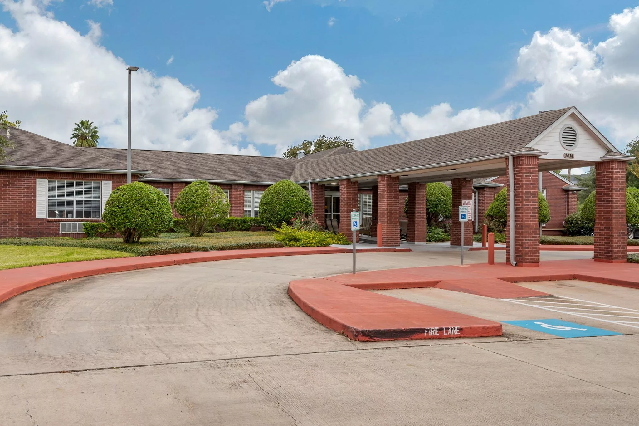 Front entrance of a senior living facility with landscaped grounds