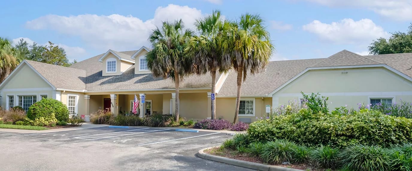 Exterior view of a nursing home with palm trees