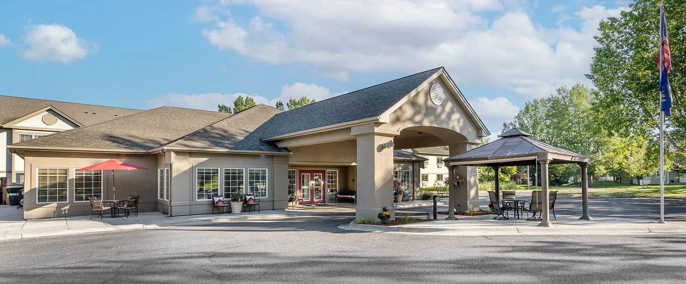 Exterior view of a senior living facility with patio.