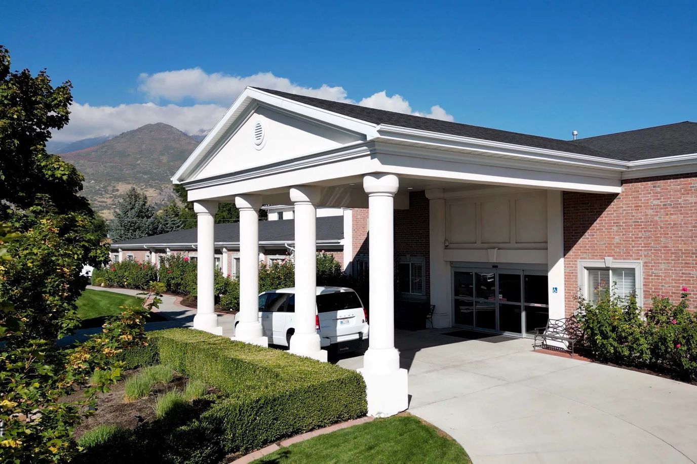 Front entrance of a senior living facility with landscaped gardens