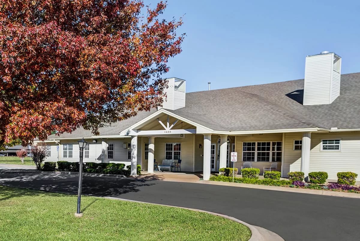 Exterior view of Chisholm Court facility with colorful tree