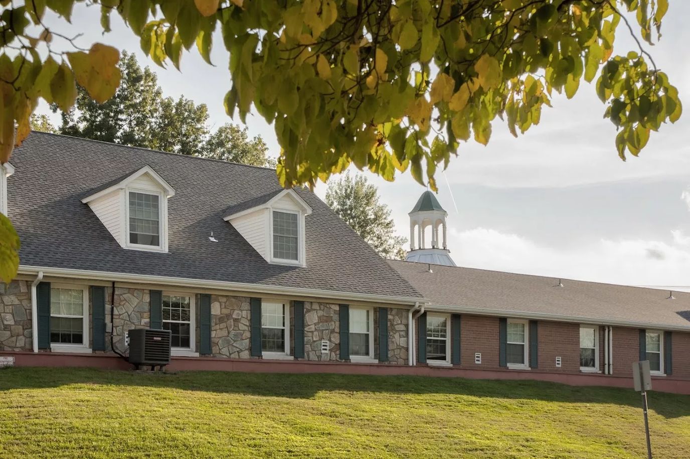 Exterior view of a senior living facility surrounded by trees