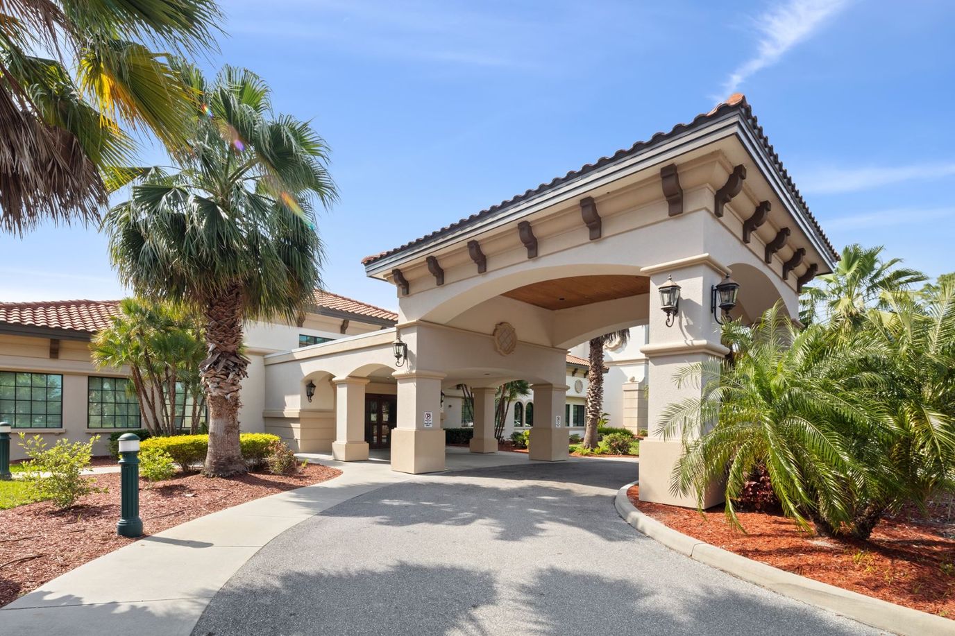Exterior view of the facility entrance surrounded by palm trees