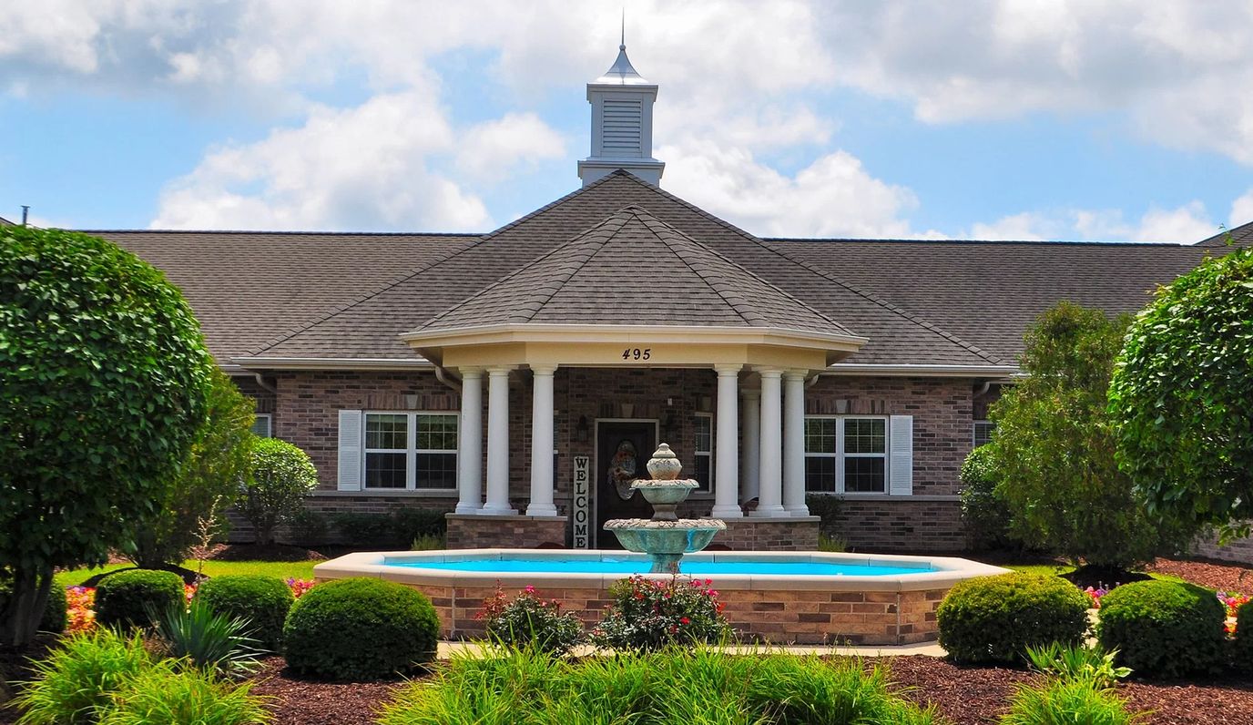 Exterior view of a senior living facility with a fountain