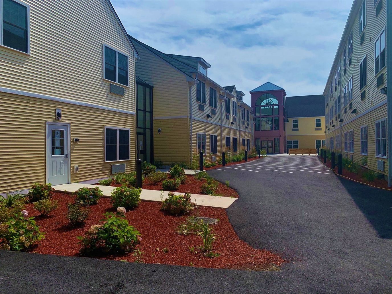 Paved entrance to a senior living facility with landscaped greenery