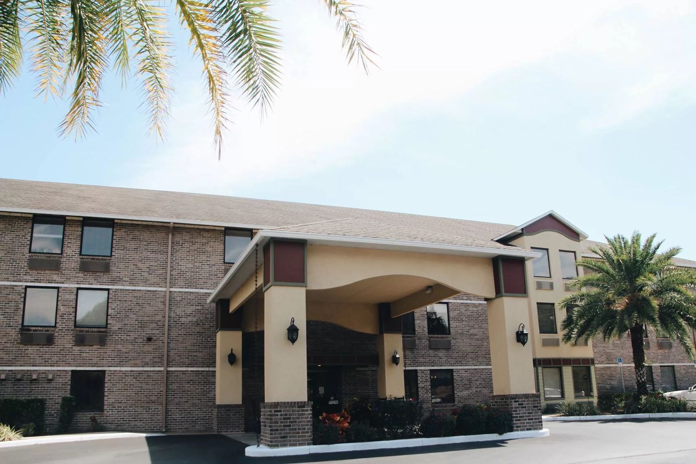 Exterior view of Grace Manor Suites with palm trees