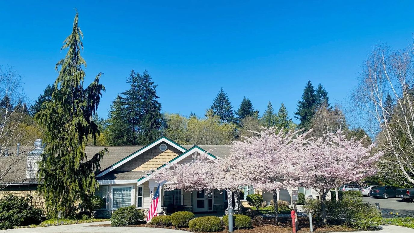 Exterior view of Highland Court Memory Care with cherry blossoms