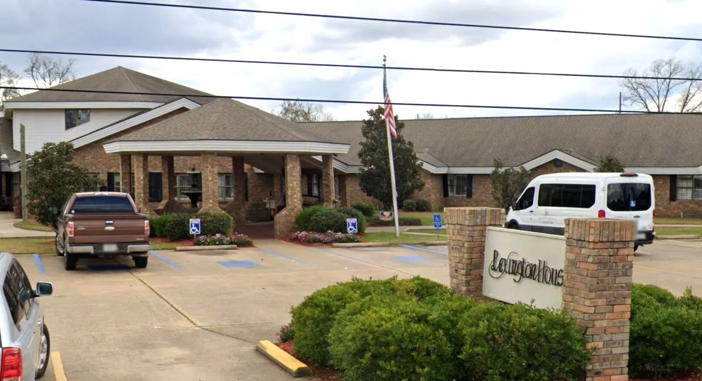 Exterior view of Lexington House with parking and transport van