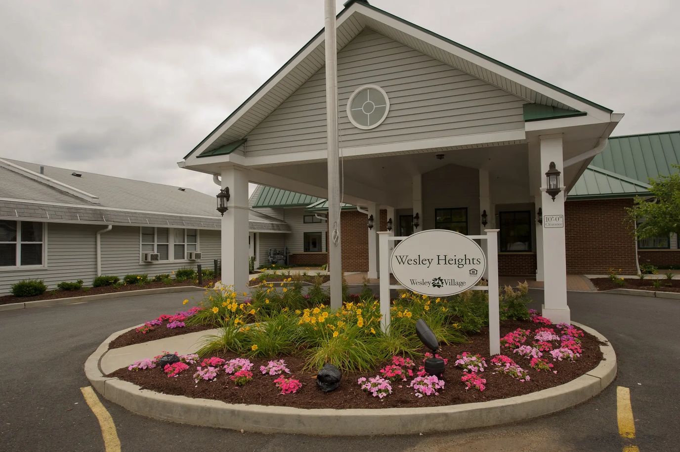 Exterior view of Wesley Heights with flowers and entrance