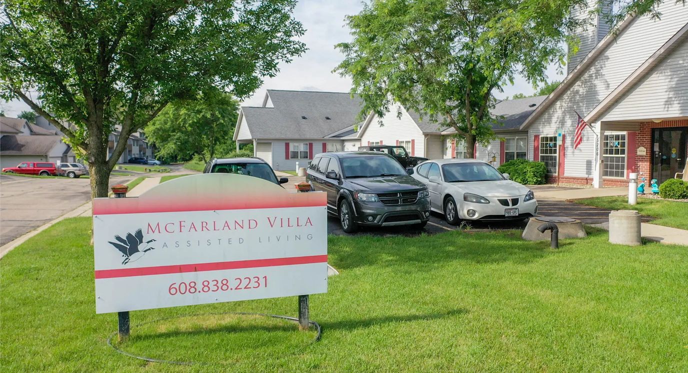 Signage for McFarland Villa Assisted Living with vehicles parked