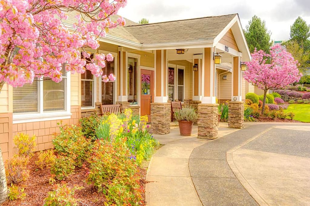 Exterior view of a memory care facility with blooming trees