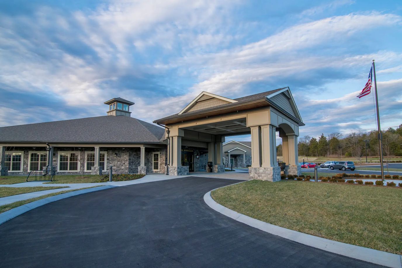 Exterior view of a senior living facility with a flag