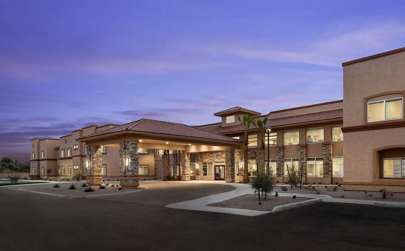 Exterior view of a senior living facility at dusk