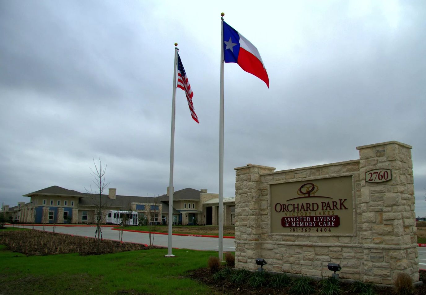 Exterior view of Orchard Park assisted living facility with flags
