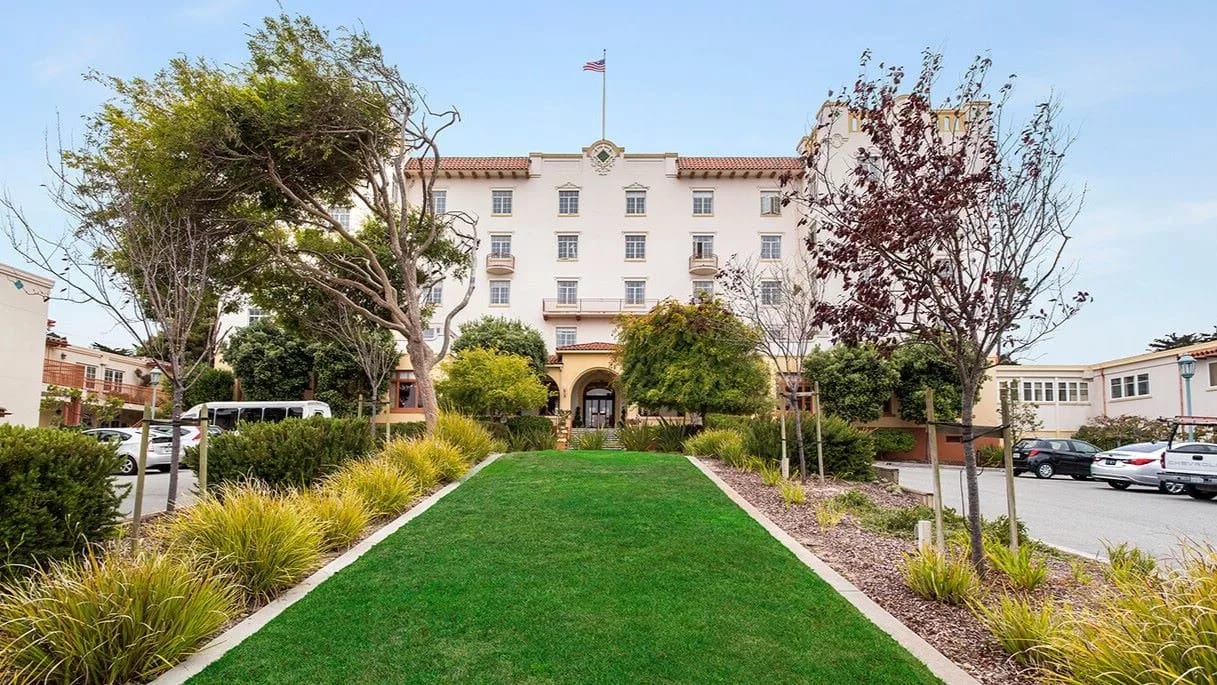 Exterior view of Pacific Grove Senior Living surrounded by greenery