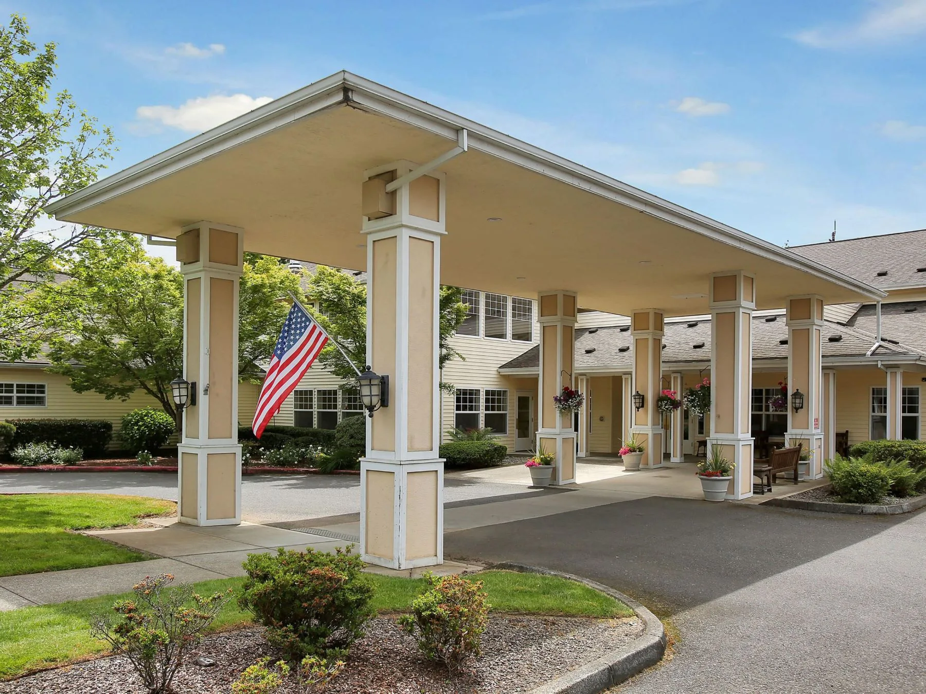 Entrance of Prestige Senior Living Huntington Terrace with American flag