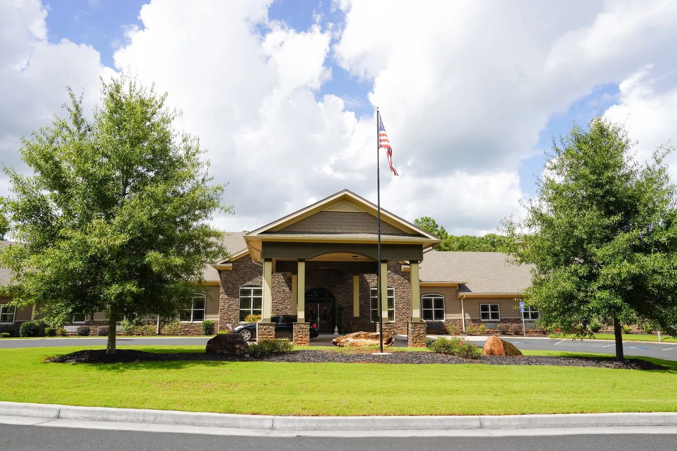 Exterior view of River Place at Forsyth with lawn and flag