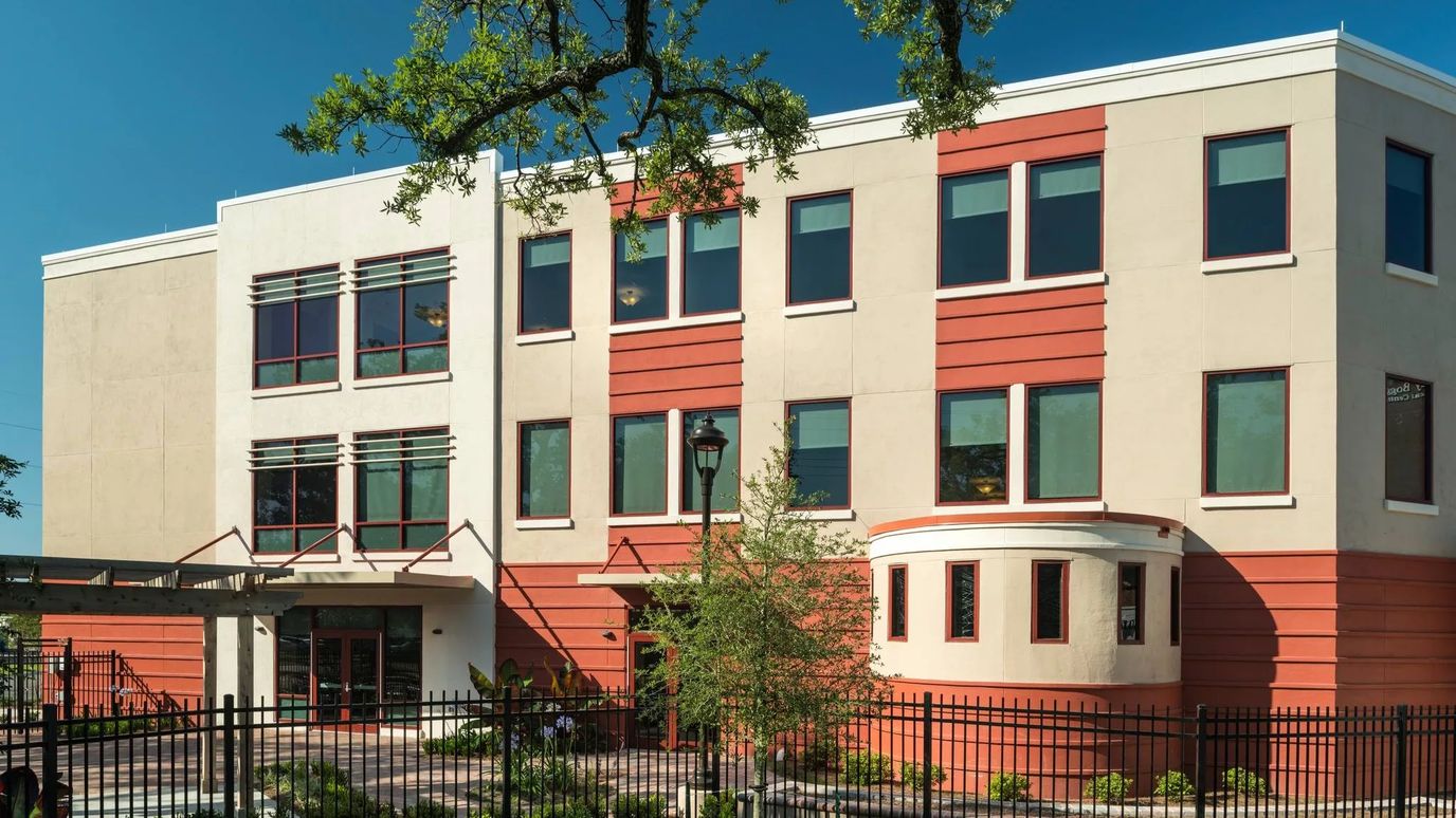 Exterior view of a senior living facility with gardens and walkways