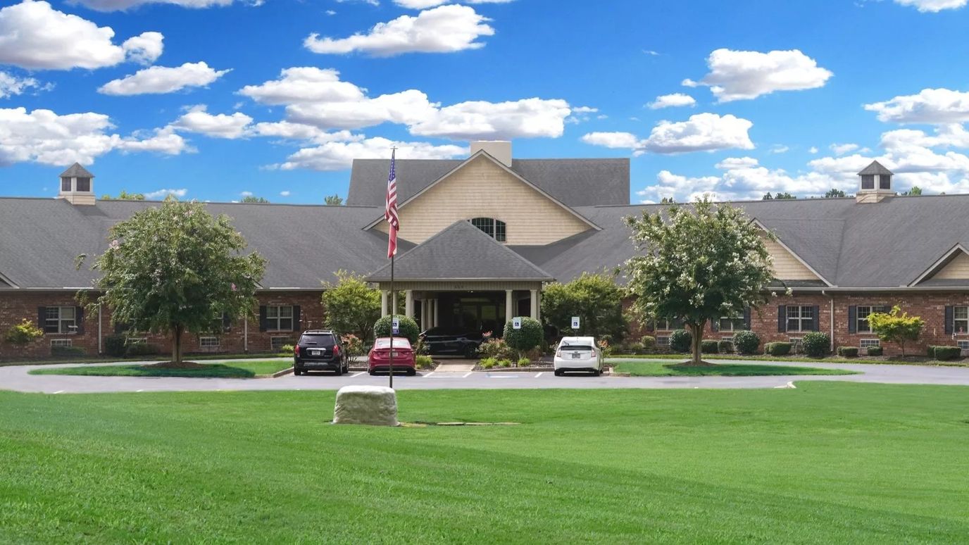 Exterior view of Sunny Grove Assisted Living surrounded by green lawn