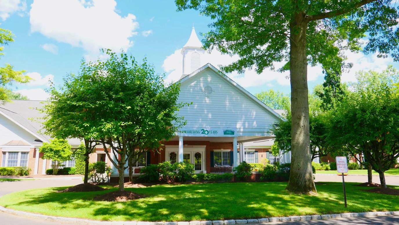 Exterior view of a senior living facility surrounded by trees
