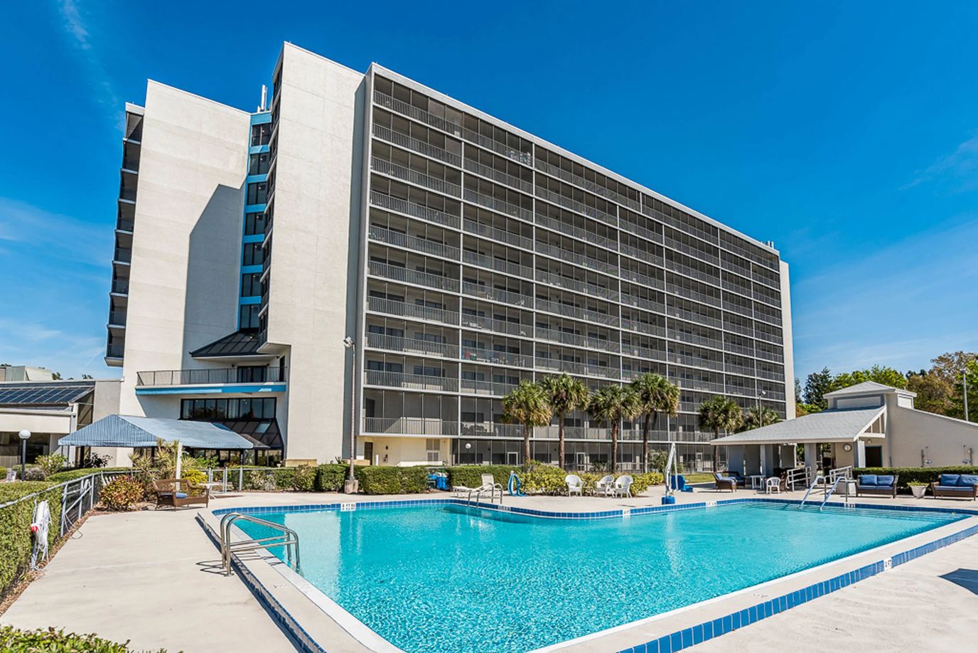 Pool area with a large residential building behind