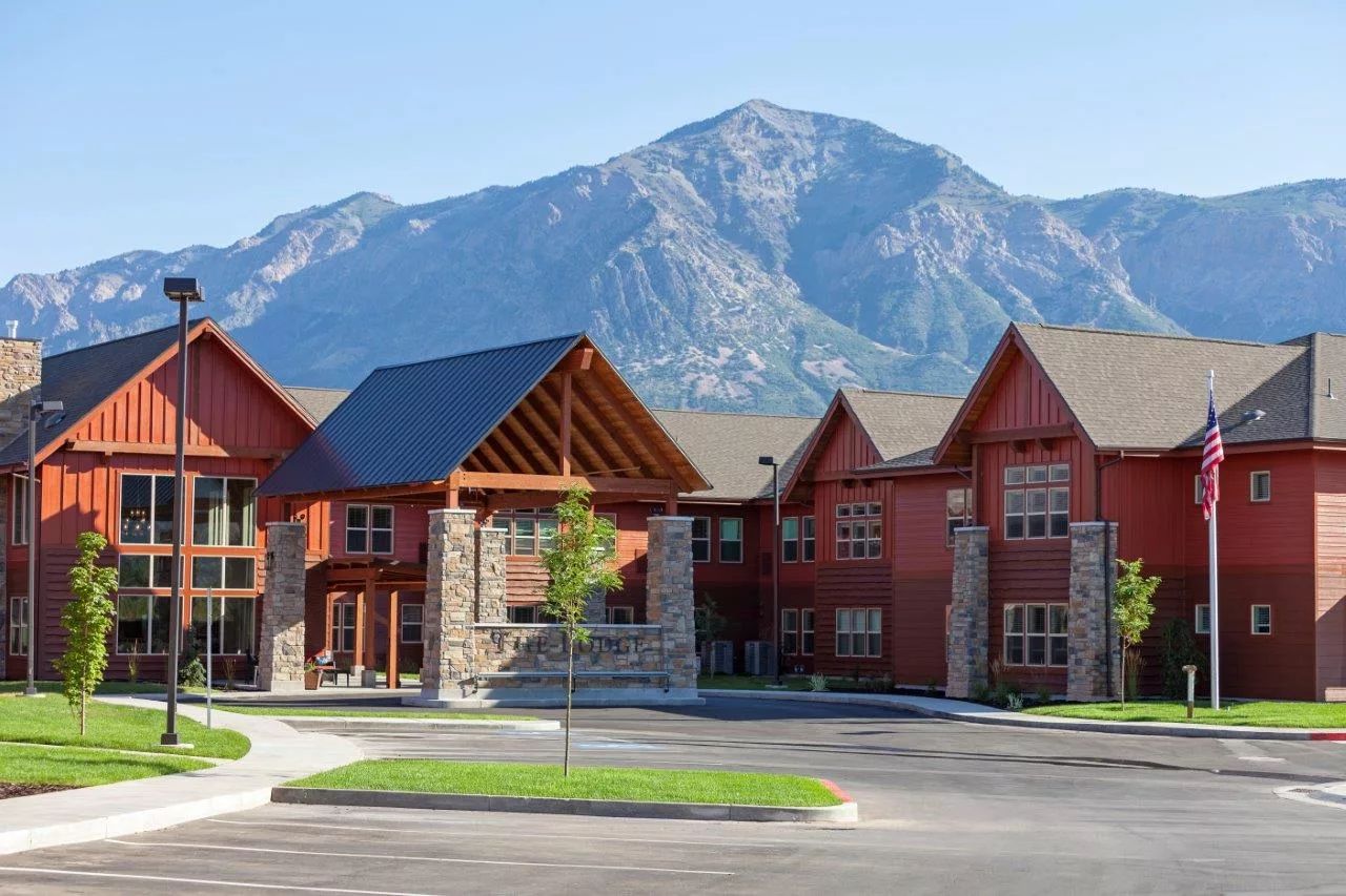 Exterior view of a senior living facility surrounded by mountains