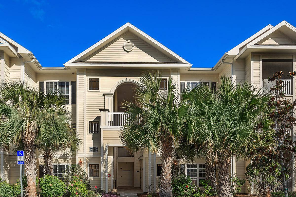 Exterior view of a senior living facility with palm trees
