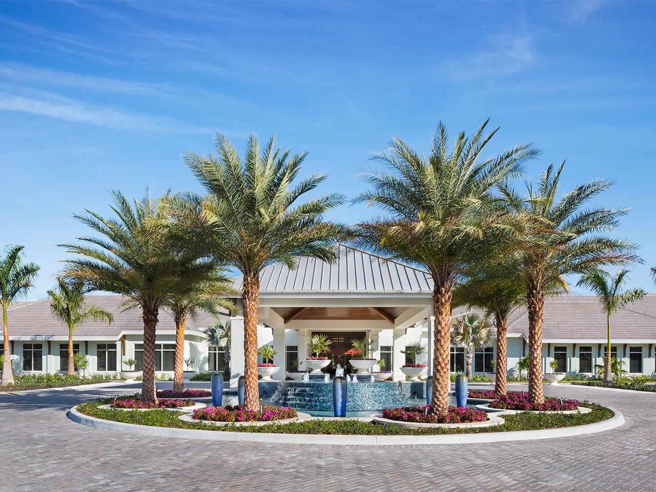 Beautiful entrance of a senior living facility with palm trees