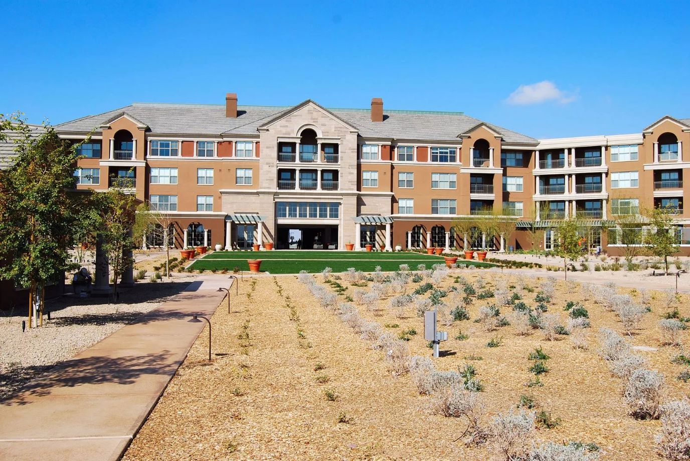 Exterior view of a senior living facility with gardens