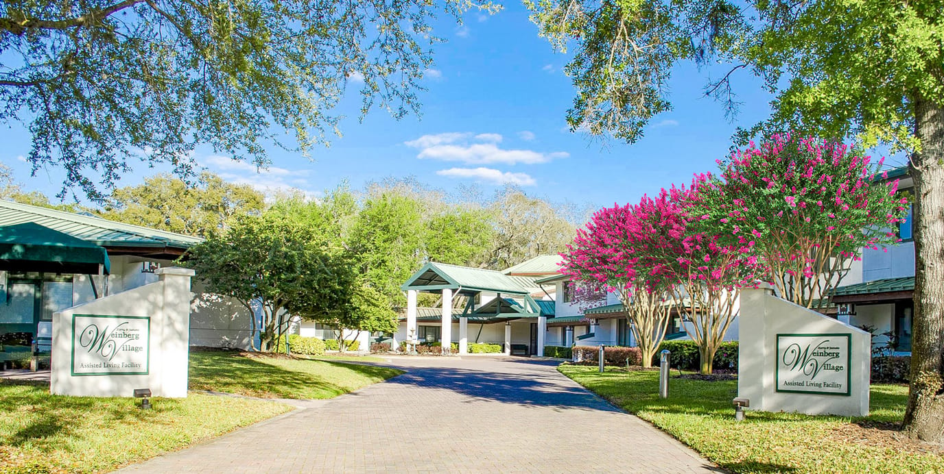 Entrance to Weinberg Village Assisted Living with vibrant flowers