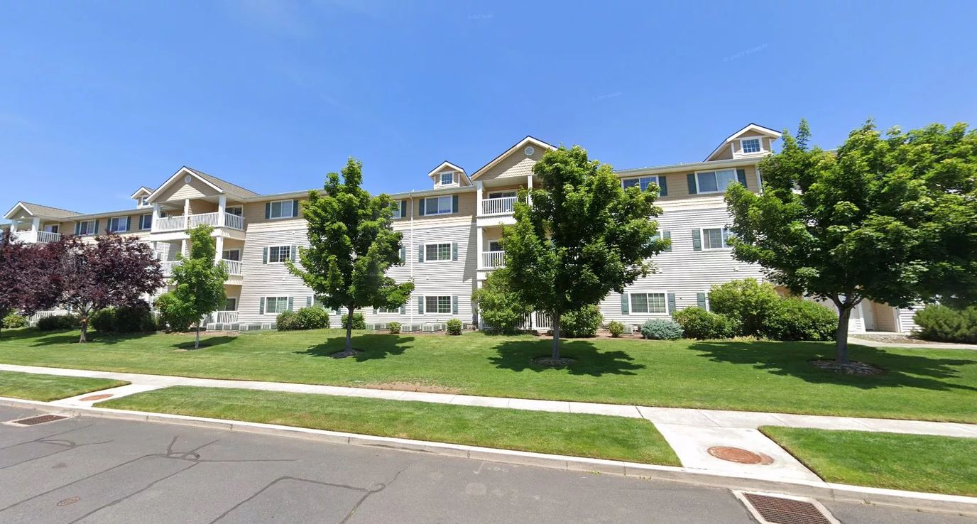 Exterior view of a senior living facility with landscaped area