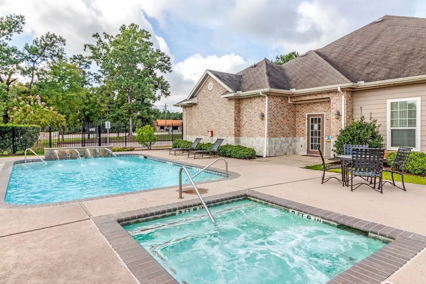 Outdoor swimming pool and hot tub area at Woodside Manor