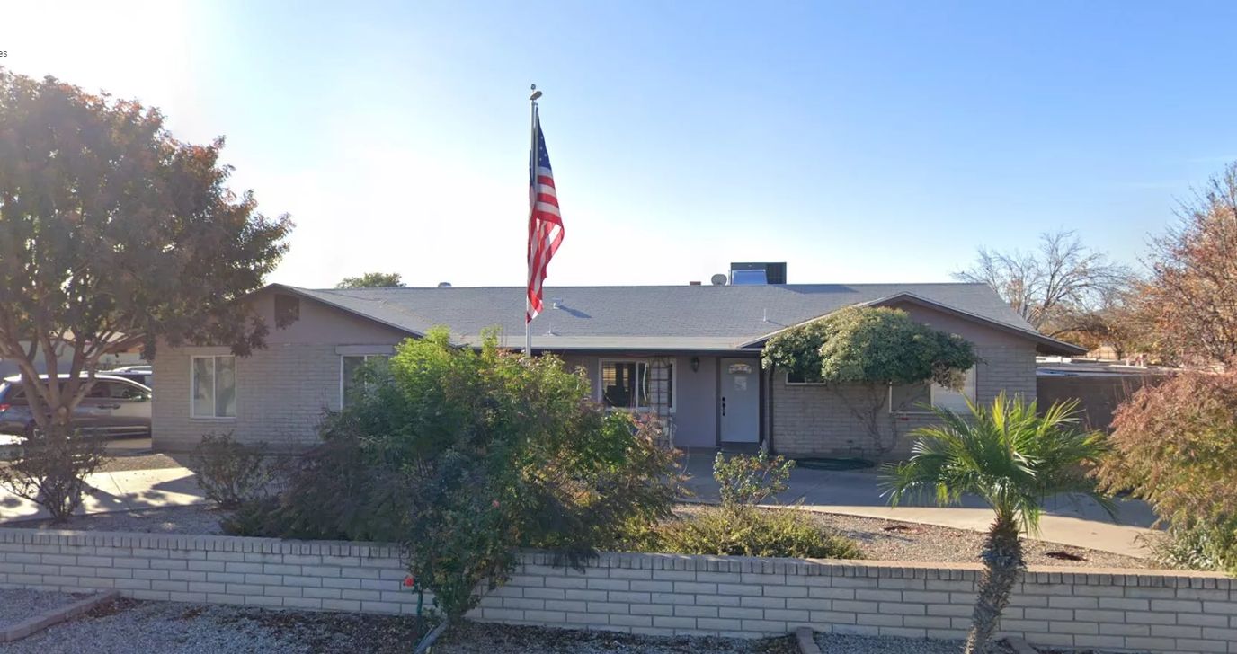 Exterior view of a senior care facility with flag