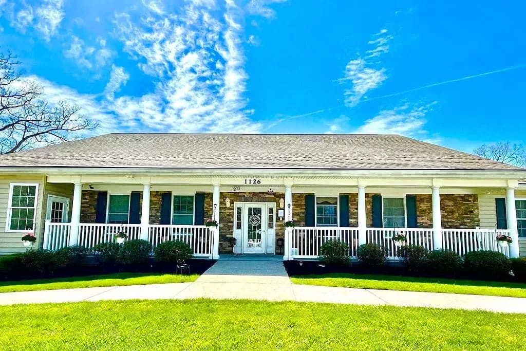 Exterior view of Alcoeur Gardens facility with a porch
