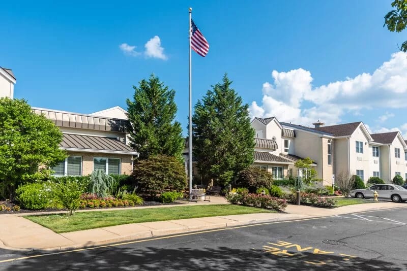 Exterior view of Spring Oak at Toms River with garden and flag