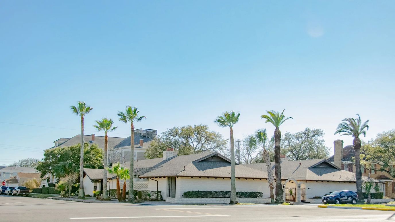 Exterior view of a senior living facility with palm trees