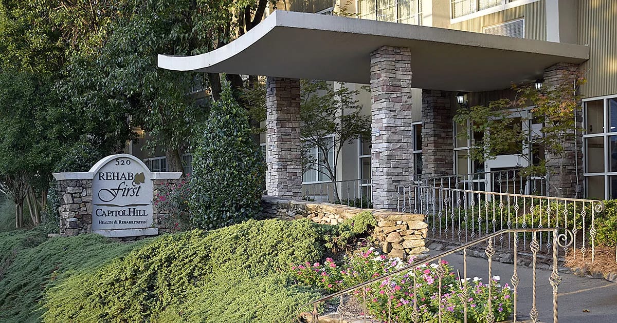 Exterior view of a senior living facility entrance with gardens