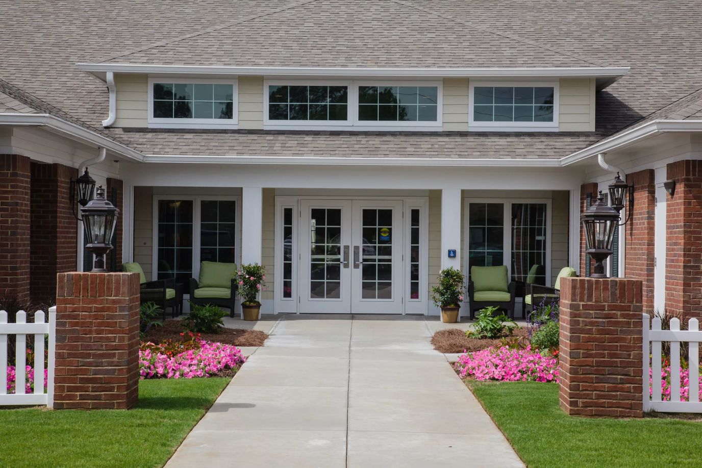 Front entrance of a senior living facility with flower beds